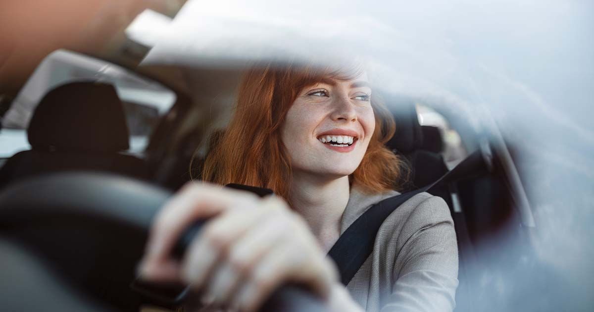 Woman smiling while driving. 